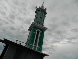 foto do a mesquita torre ocupado a partir de a topo chão do uma de vários andares prédio. a mesquita torre é usava Como uma marcador e Além disso Como uma Alto-falante