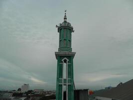 foto do a mesquita torre ocupado a partir de a topo chão do uma de vários andares prédio. a mesquita torre é usava Como uma marcador e Além disso Como uma Alto-falante