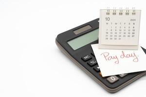 mão escrevendo texto pagar dia em Outubro calendário com calculadora dentro isolado fundo. lembrete conceito do pagamento. cópia de espaço. foto