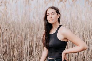 feliz jovem sorridente mulher com sardas ao ar livre retrato. suave ensolarado cores. ao ar livre fechar-se retrato do uma jovem morena mulher e olhando para a Câmera, posando contra outono natureza fundo foto