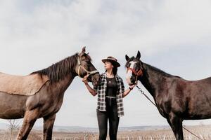 jovem feliz mulher dentro chapéu com dela cavalo dentro tarde pôr do sol claro. ao ar livre fotografia com moda modelo garota. estilo de vida humor. conceito do ao ar livre cavalgando, Esportes e lazer. foto