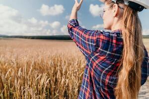 mulher trigo campo. agrônomo, mulher agricultor Verifica dourado maduro cevada espigões dentro cultivado campo. fechar-se do fêmea mão em plantação dentro agrícola colheita gestão conceito. lento movimento foto