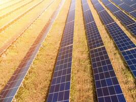 aéreo topo Visão do uma solar painéis poder plantar. fotovoltaico solar painéis às nascer do sol e pôr do sol dentro campo a partir de acima. moderno tecnologia, clima Cuidado, terra salvando, renovável energia conceito. foto