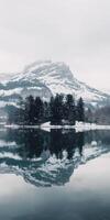 coberto de neve montanha reflexões dentro calma lago foto