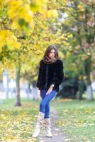lindo jovem mulher caminhando dentro outono parque. outono moda conceito. foto