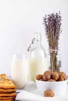 fresco saudável leite, biscoitos com passas de uva, nozes, grupo do seco cortar lavanda em branco fundo. seletivo foco. foto