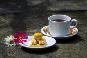 queijo bolo com chá e flores ao lado foto