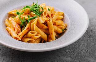 macarrão penne com molho de tomate foto