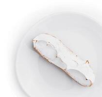 eclair com merengue em branco prato topo Visão foto