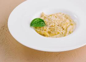 Macarrão Penne massa com parmesão dentro branco prato foto