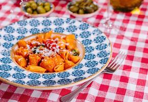 chefe de cozinha grades queijo para a prato com fresco Macarrão Penne massa foto