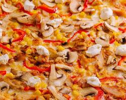 pizza com Sino pimentas, milho, carne e cogumelos fechar acima foto