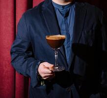 homem dentro terno segurando espresso martini coquetel foto