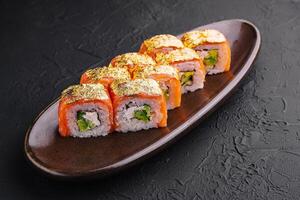luxo ouro folha Sushi rolos em Sombrio prato foto
