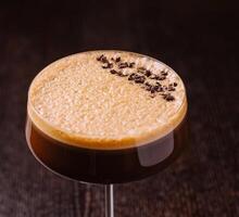 elegante espresso martini coquetel em Sombrio fundo foto