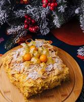 festivo napoleão bolo em de madeira prato com Natal decoração foto