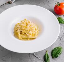 fettuccine Alfredo com carne molho servido em branco prato foto