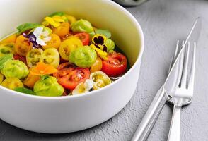 fresco tomate salada com comestível flores foto