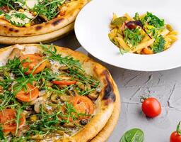 gourmet vegetal pizzas e massa em mesa foto