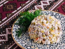 tradicional olivier salada em ornamentado prato foto