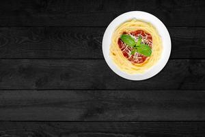 close-up vista de espaguete de queijo isolado na mesa de madeira preta. foto