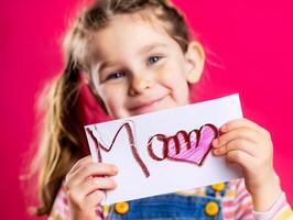 pequeno menina dando dela mão escrevendo cumprimento cartão para dela mãe. foto