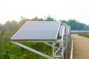 solar poder geração estação, elas instalado de várias solar painéis em uma concreto barreira ao longo a rio para gerar eletricidade para bomba água para agrícola usar. foto