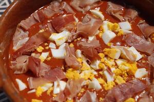 espanhol comida, frio tomate sopa chamado Salmorejo com fervido ovo e cru presunto foto
