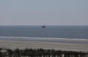 barco a vela em a norte mar, visto a partir de a costa foto