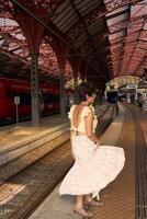 uma menina com uma curto corte de cabelo dentro uma amarelo vestir às a trem estação dentro copenhaga foto