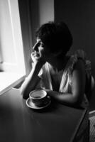 uma menina com uma curto corte de cabelo dentro uma restaurante, Preto e branco foto dentro vintage estilo