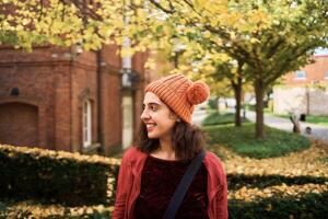 uma menina dentro uma chapéu com pompons anda em a ruas do Bruges em a outono dia foto