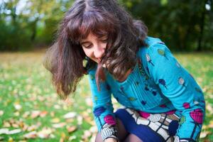 uma menina dentro uma vestir com balões é jogando dentro a outono jardim foto