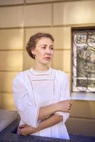 elegante meio era mulher dentro branco vintage vestir perto teatro com Antiguidade colunatas foto