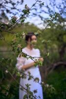 lindo mulher dentro branco vintage vestir com trem dentro Primavera jardim às pôr do sol foto