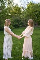 dois mulheres abraço e pose contra a fundo do natureza foto