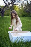 uma fofa menina dentro uma pastel vestir desenha com areia em uma especial mesa foto