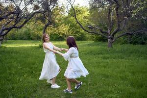 uma mãe e dela Adolescência filha estão abraçando e jogando dentro a jardim foto