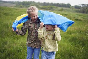 dois pequeno meninas dentro a campo debaixo a ucraniano bandeira dentro chuva foto