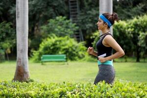 mulher corrida com fones de ouvido dentro a parque foto