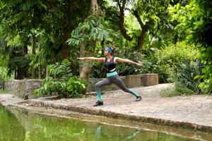 mulher exercício Guerreiro 2 ioga pose dentro manhã dentro a parque foto