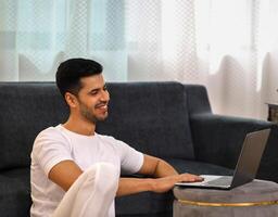 risonho face homem assistindo conectados em computador portátil foto