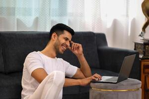 homem sorridente e olhando às computador portátil foto