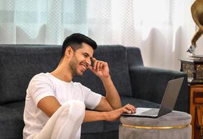 jovem cara sorridente e sentado em chão foto