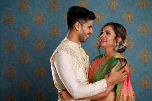 imagem do uma amor casal vestindo tradicional indiano roupas sorridente e abraçando foto