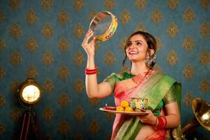 indiano dona de casa dentro saree segurando karva Chauth puja prato dentro mão foto