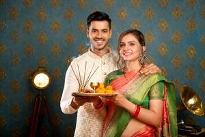 imagem do Boa casal segurando pooja prato durante a diwali celebração foto