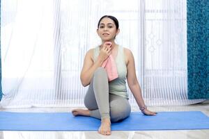 cansado mulher limpando dela suor com toalha depois de exercício foto