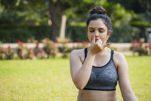 uma fechar acima do uma em forma ásia fêmea fazendo respiração exercício. foto