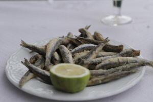 boquerones ou frito sardinha em uma prato com limão, frutos do mar dentro Espanha foto